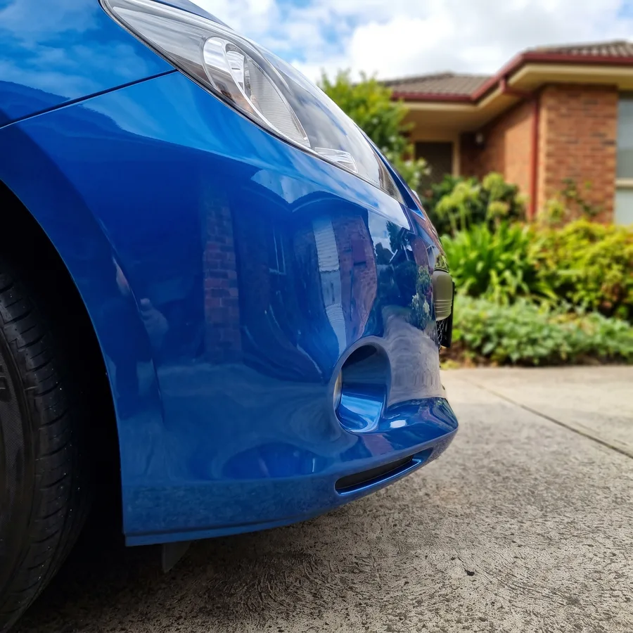 The same blue hatchback front bumper corner resprayed smooth and colour-matched