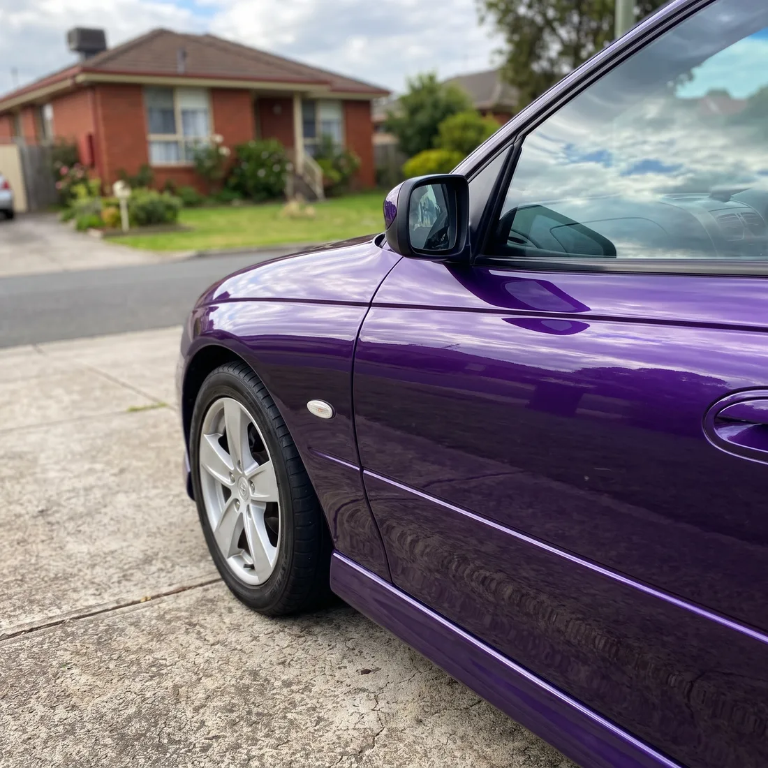 The front guard of a purple sedan after a custom colour-matched respray