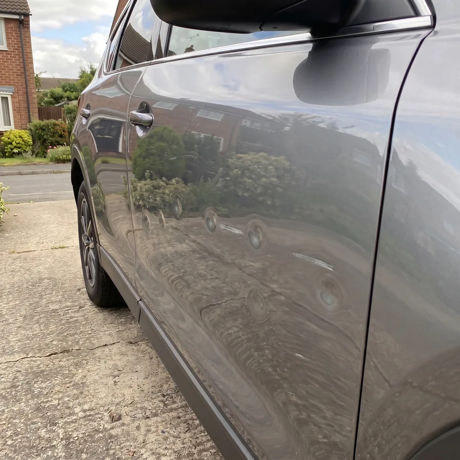 Shopping-trolley dings across a car door before repair