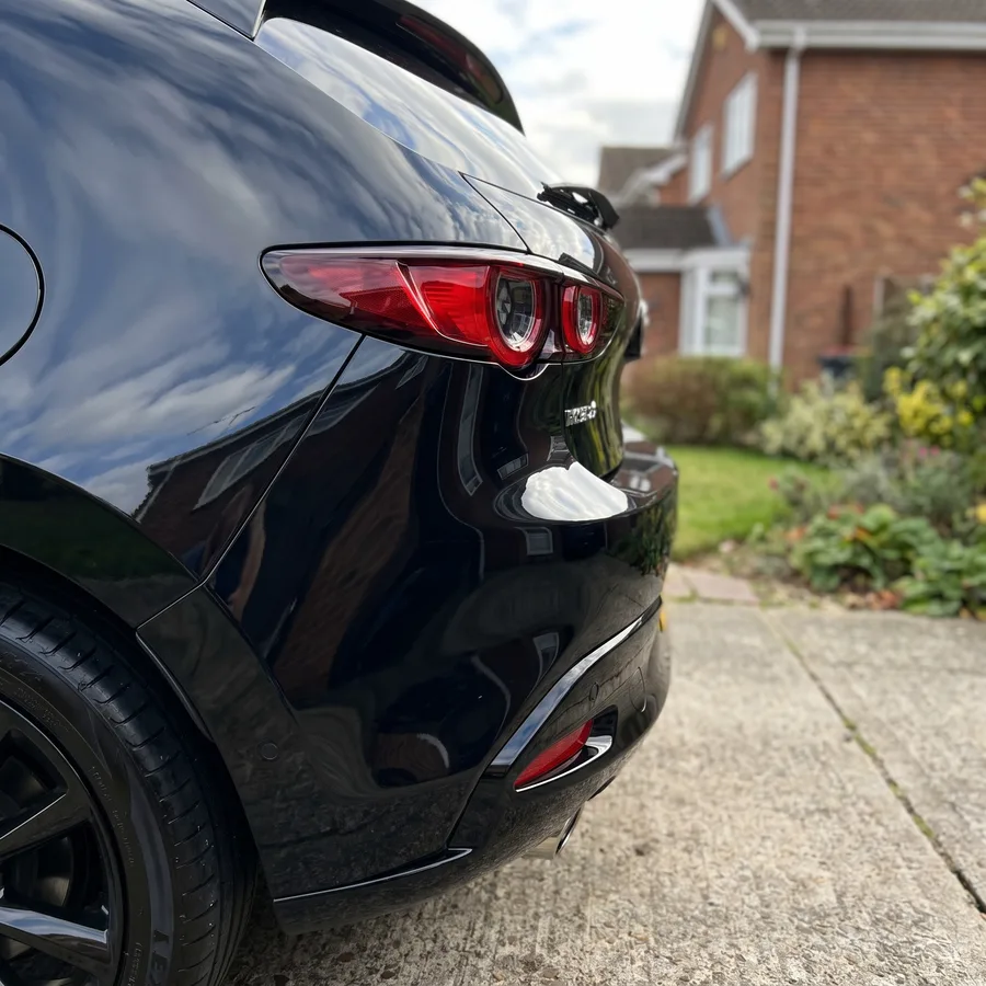 The same black hatchback rear bumper corner polished clean and colour-matched