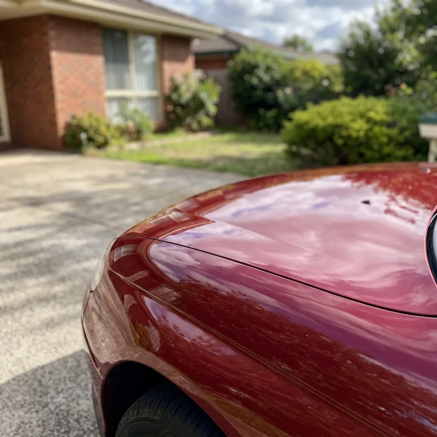 The same red sedan bonnet edge touched up and polished clean